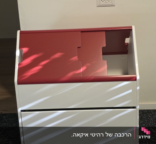 ארון לבן עם מכסה אדום על רצפה שחורה